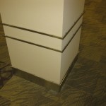 detailed view of stainless steel baseboard and ornamental work on square column