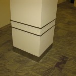 detailed view of stainless steel baseboard and metal ornamental work on square column