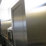 long view of stainless steel walls with kitchen fridges