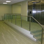 metal handrail near ramp and elevator on small glass stairway
