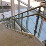 metal and glass handrail on marble stairs