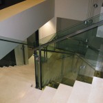 top view of metal handrail on glass panel stairway