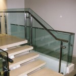detail of metal handrail on glass panel stairway