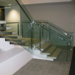 side view of metal handrail on glass panel stairway